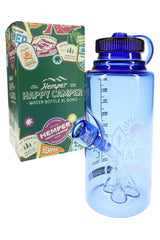Hemper Happy Camper Water Bottle XL glass bong in blue posed beside sticker-covered green retail box, angled product view.