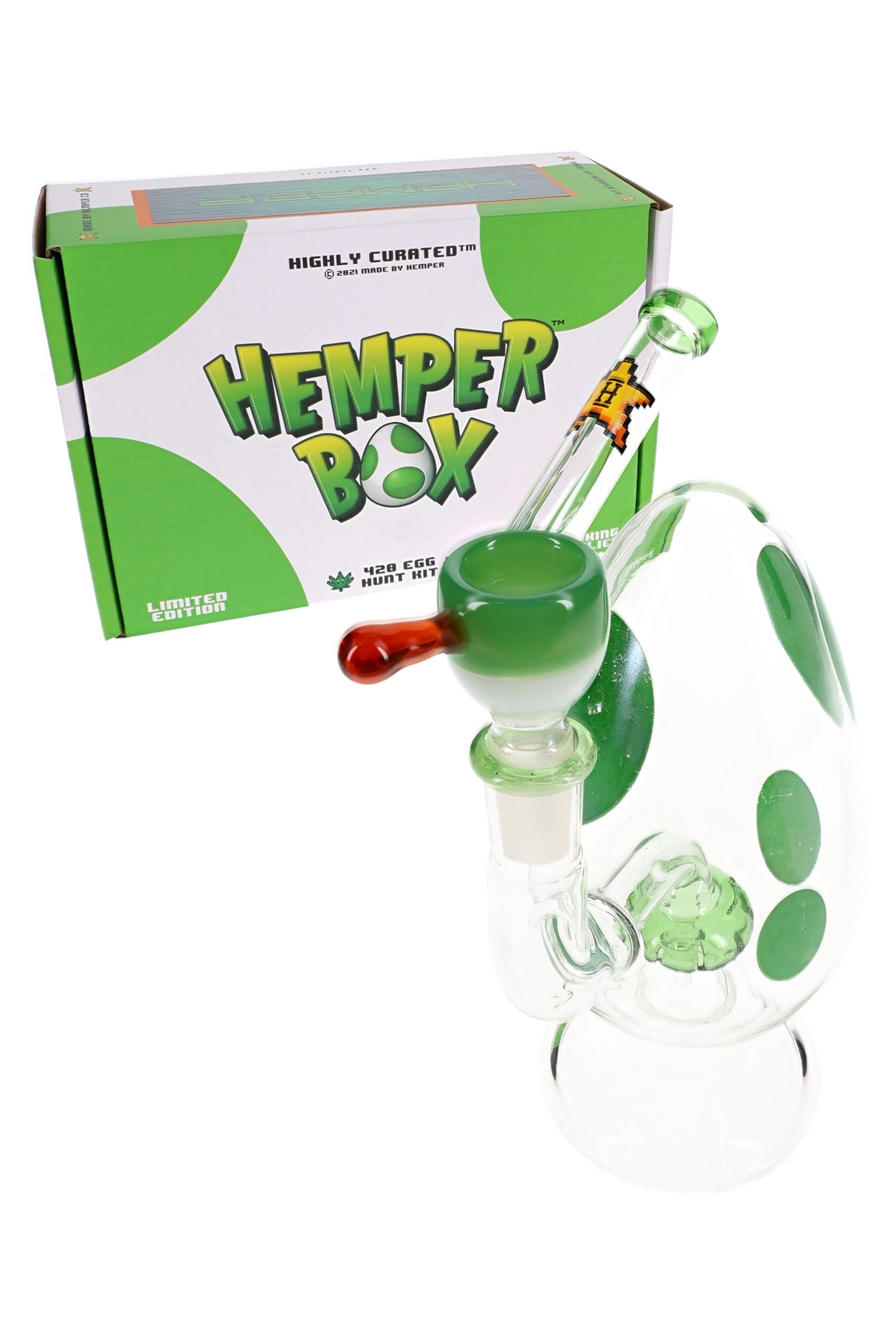 Green-spotted egg bong posed in front of Hemper Box packaging labeled 420 Egg Hunt Kit.