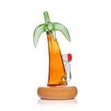 Side profile palm tree glass bong showing amber trunk, green fronds silhouette, and wide sand-colored base for stability