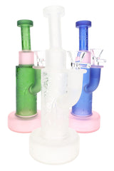 Three frosted space-style glass bongs in green, white, and blue with pink bases and matching bowl slides