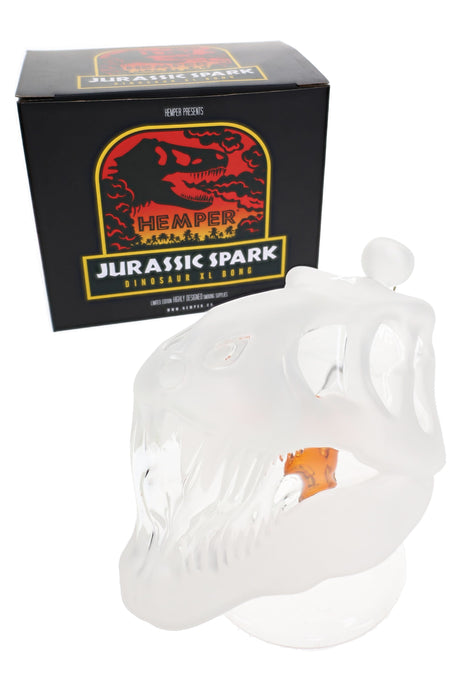 Hemper Jurassic Spark skull glass bong with retail box, frosted dinosaur skull shape and amber “ember” detail inside