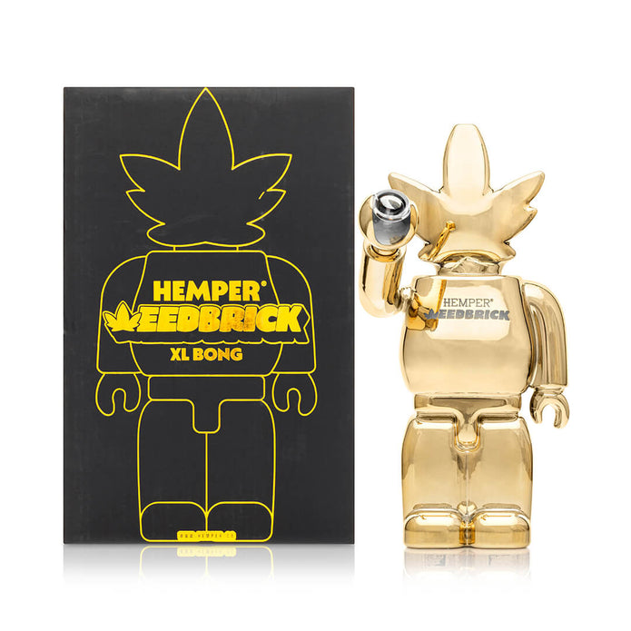 Hemper Weedbrick XL retail box beside mirror-gold bong, display-ready packaging with high-shine character silhouette