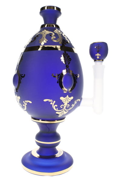 Close-up of XL jeweled egg glass bong with ornate blue body, clear stem section, and novelty display styling