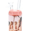 Mini bottle-style glass bong with pink top, clear mouthpiece, cheeky beach decal, and compact cup body
