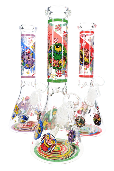Assorted decal glass beaker bongs showing festive monster artwork, bowls, and swirled bases