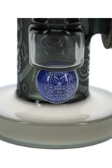 Blue hieroglyphic accent on stone alien glass bong near unique perc and frosted base detail