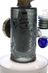 Side view of stone alien glass bong with clear bowl, raised medallion, and etched geometric artwork