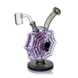 Three-quarter view of MJ Arsenal Nightcrawler dab rig with dimensional purple spiderweb body, black spider, and banger