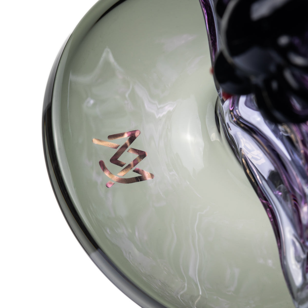 Close-up of MJ Arsenal Nightcrawler dab rig dark round base with metallic MJ Arsenal logo beside purple spiderweb glass