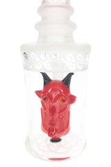 Close-up of a red demon-head perc with black horns, orange eyes and pointed ears inside a clear glass chamber.
