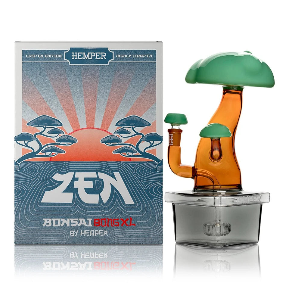 Hemper Bonsai XL glass bong beside its illustrated box, showing green treetops, an amber trunk and matching bowl