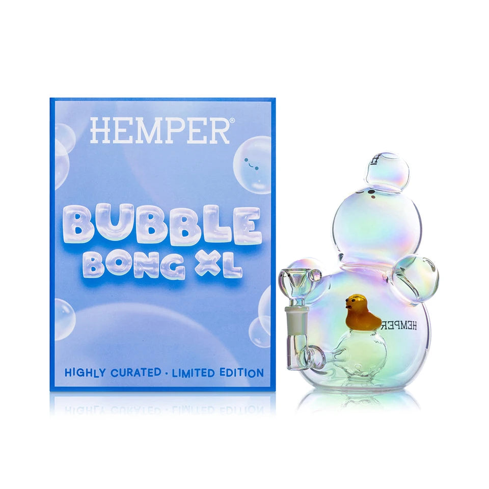 Hemper Bubble XL iridescent glass bong with a yellow duck inside beside its blue illustrated retail box