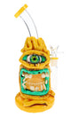 Yellow 6B Glass cyclops bong with oversized green eye, tooth-lined mouth, honeycomb perc, and clear bent neck.