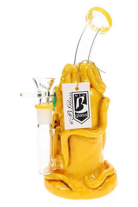 Rear view of yellow 6B Glass cyclops bong with winding resin details, clear bent neck, handled bowl, and brand tag.
