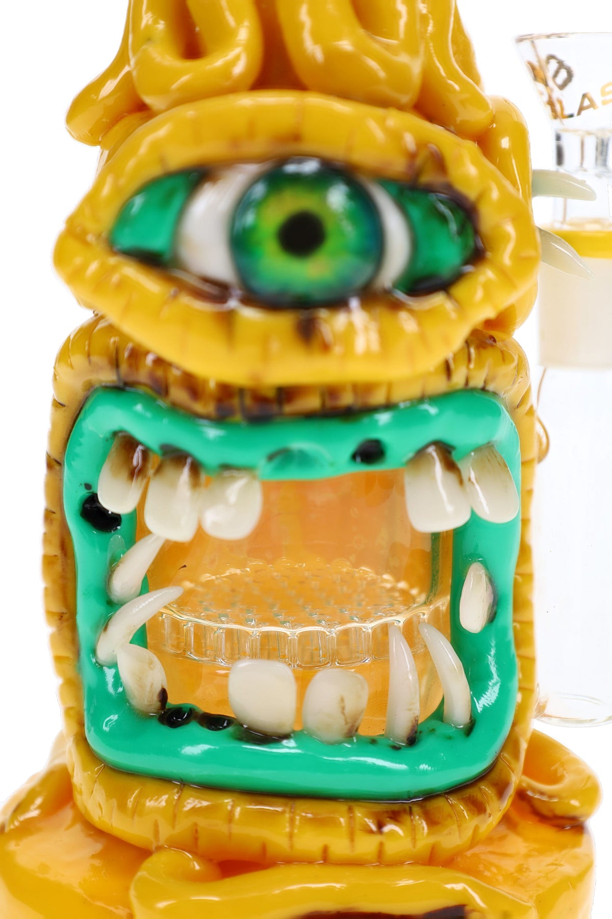 Close-up of cyclops bong with green eye, sculpted teeth, and honeycomb perc visible through the open mouth.
