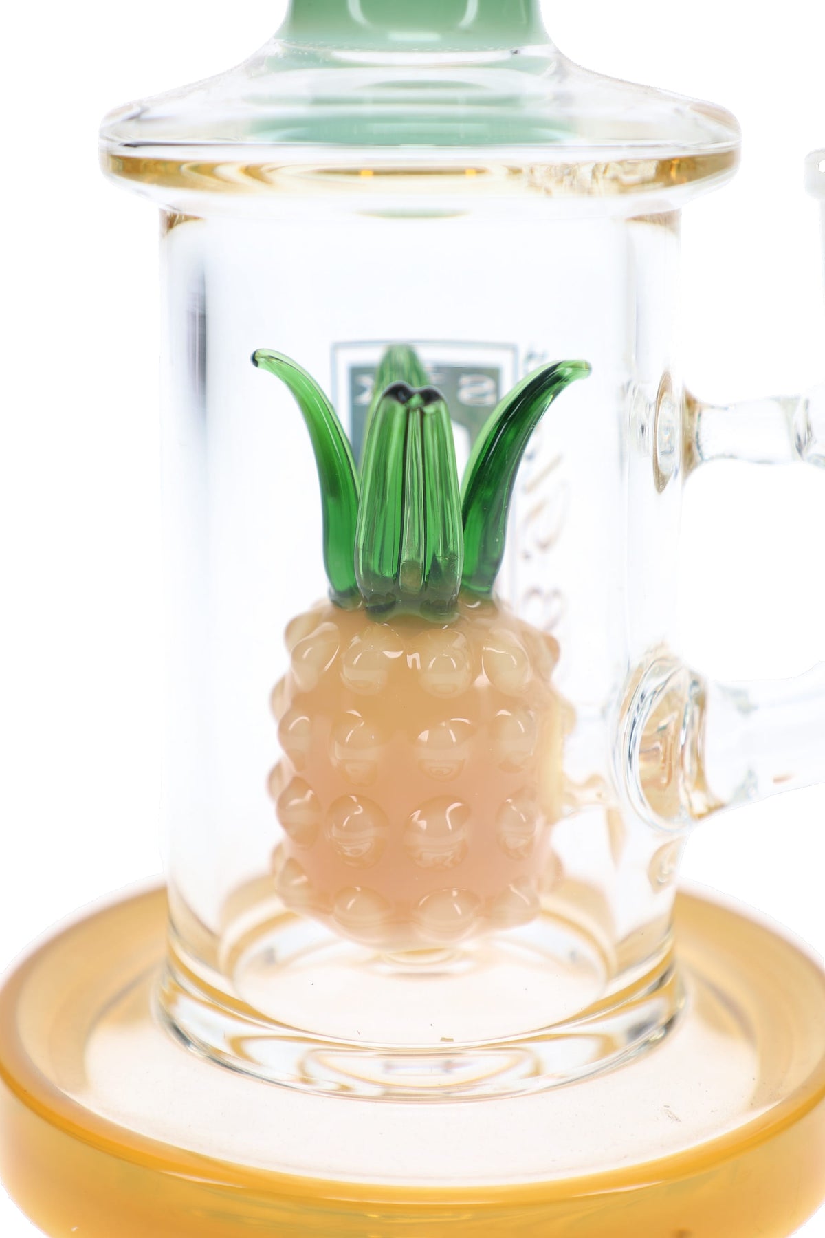 Close-up of pineapple-shaped glass percolator with raised yellow fruit details and green leaves inside a clear bong.
