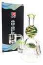 6B Glass reverse tree perc dab rig with multicolor zigzag accents, green mouthpiece, clear banger, and branded box.