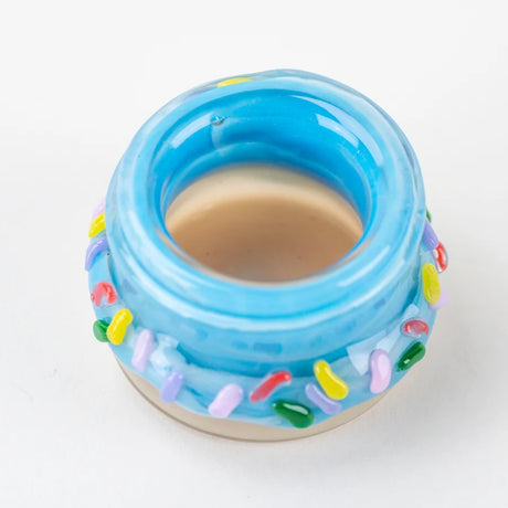 Open blue glass donut terp jar with beige base and multicolor sprinkles, angled rim perspective