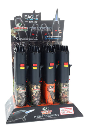 12-piece counter display of Eagle pen torch lighters with Mossy Oak camo barrels, Safe-Stop branding, flame-lock switches, and jet-torch styling.