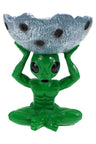Green alien figurine seated cross-legged, hoisting crater-textured silver bowl resin ashtray overhead, detailed black eyes and muscular torso.