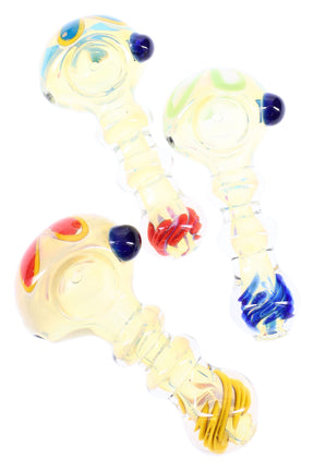 4-inch silver-fumed glass spoon pipe with stacked ring grip, side carb, and encased color coil in tail; assorted accent colors.