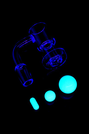 Clear quartz terp slurper banger with 14.5 mm male joint and glow-in-the-dark marble, pearl, and pillar inserts under blacklight.