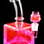 Pink fluid-filled cube bong close-up with curved neck and matching glass bowl on a stemless joint, glossy finish.
