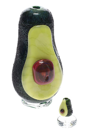 Avocado-shaped glass Puffco Peak attachment on a clear foot, textured dark rind with glossy pit accent, US-made artisan piece.