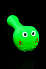 Bright green silicone pipe featuring a smiling frog cap; compact spoon with hidden bowl.