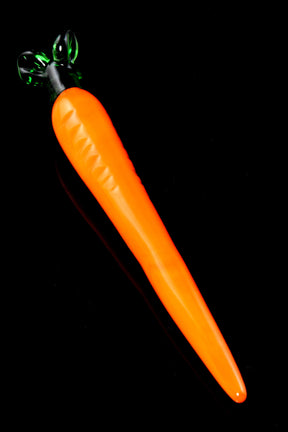 Glass carrot-shaped dab tool, 5 inches long, vivid orange body with green leafy handle and tapered point, displayed on glossy black background.