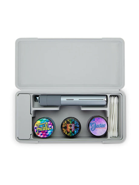 Open Pivot travel case loaded with a pen, three concentrate jars and cotton swabs, showing tidy silicone compartments.