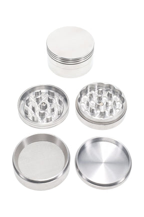 2½″ 4-part metal herb grinder shown disassembled with magnetic lid, sharp teeth, mesh pollen screen, and deep kief catch base.