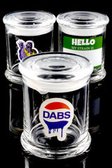 Trio of large glass stash jars on glossy black surface featuring assorted decals—DABS logo, Thanos snap, blank strain label—illustrating random design