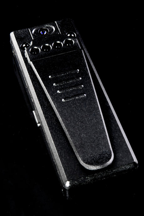 Rear view of mini HD recorder with spring metal clip, six infrared LEDs, and hidden lens on black backdrop