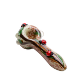 Angled 4½″ glass hand pipe with three red ladybugs, earthy speckled bowl, and clear grip marbles