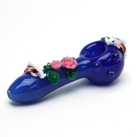 Three-quarter view of Empire Glassworks hand pipe with blue pond design, koi accents, and floral glasswork