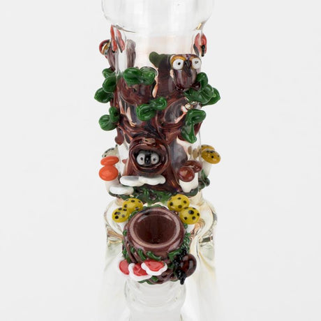 Macro close-up of hand-sculpted owl perched among green vines and red mushrooms on Hootie's Forest bong, highlighting intricate lampwork